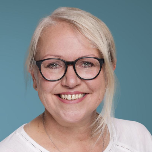 Janina Goldbaum Fotodummy, Weiße Mütze mit einem blauen Kreuzsymbol auf einem neutralen Hintergrund.